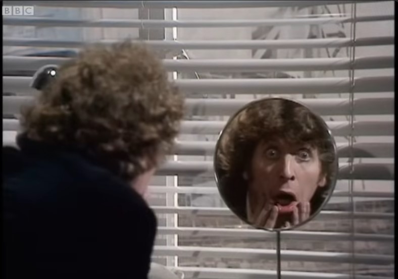 Fourth Doctor (doctor who) wildly gawking in the mirror.